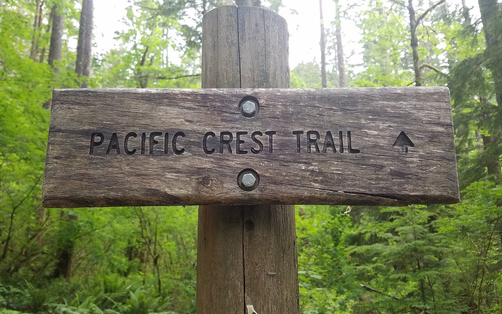 A metal distance marker bolted to a post, close